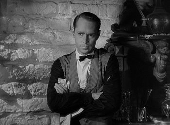 Movie still from “Five Graves to Cairo” (1943), directed by Billy Wilder – A man standing in front of a brick wall; Close Up shot, Low angle
