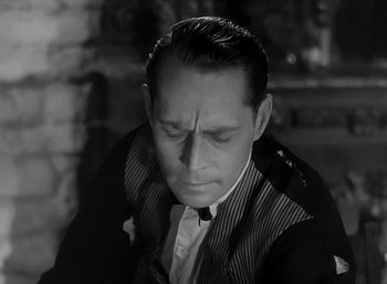 Movie still from “Five Graves to Cairo” (1943), directed by Billy Wilder – A man in a black and white photo looking down at his face; Close Up shot, High angle