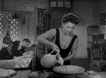 Movie still from “Five Graves to Cairo” (1943), directed by Billy Wilder – A woman pouring water into a bowl on a table; Medium shot, Low angle