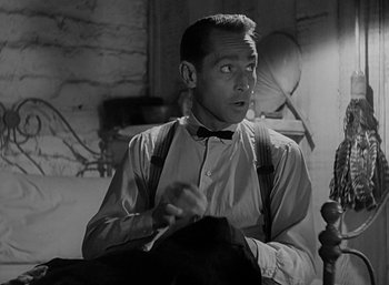 Movie still from “Five Graves to Cairo” (1943), directed by Billy Wilder – A black and white photo of a man in a bow tie and suspenders; Close Up shot, Low angle