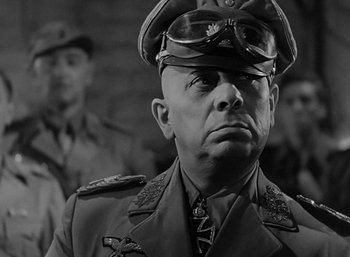 Movie still from “Five Graves to Cairo” (1943), directed by Billy Wilder – A man in a military uniform is looking at the camera; Close Up shot, Low angle