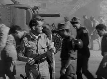 Movie still from “Five Graves to Cairo” (1943), directed by Billy Wilder – An old photo of a man walking in the street; Medium shot, High angle