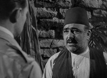 Movie still from “Five Graves to Cairo” (1943), directed by Billy Wilder – An older man wearing a fez talking to a younger man; Close Up shot, Over the shoulder angle