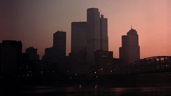 Movie still from “Flashdance” (1983), directed by Adrian Lyne – A view of a city skyline at dusk; Extreme Wide shot, High angle