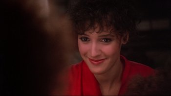 Movie still from “Flashdance” (1983), directed by Adrian Lyne – A person wearing a red shirt smiling; Close Up shot, Over the shoulder angle