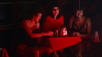 Movie still from “Flashdance” (1983), directed by Adrian Lyne – A group of women sitting at a table in a room; Medium shot, High angle