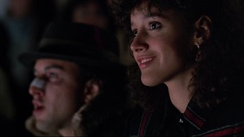 Movie still from “Flashdance” (1983), directed by Adrian Lyne – A person sitting in front of a crowd; Close Up shot, Over the shoulder angle