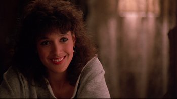 Movie still from “Flashdance” (1983), directed by Adrian Lyne – A person smiling; Close Up shot, Low angle
