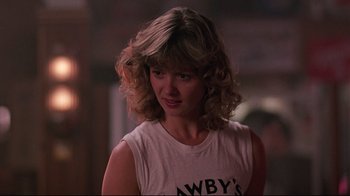Movie still from “Flashdance” (1983), directed by Adrian Lyne – A person with curly hair; Close Up shot, Over the shoulder angle