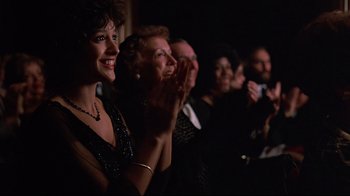 Movie still from “Flashdance” (1983), directed by Adrian Lyne – A group of people sitting in a room clapping; Close Up shot, Over the shoulder angle