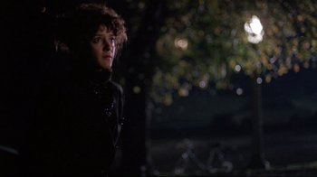 Movie still from “Flashdance” (1983), directed by Adrian Lyne – A woman standing in the dark near a tree; Medium shot, Low angle