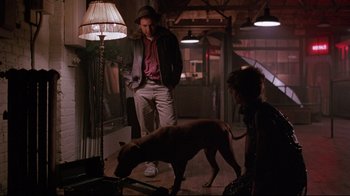 Movie still from “Flashdance” (1983), directed by Adrian Lyne – A man and a dog in a room with a lamp; Wide shot, High angle