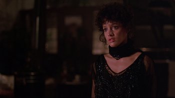 Movie still from “Flashdance” (1983), directed by Adrian Lyne – A woman in a black dress is looking at the camera; Close Up shot, Low angle