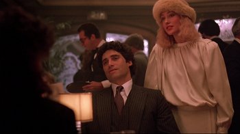 Movie still from “Flashdance” (1983), directed by Adrian Lyne – A man and a woman are sitting at a table; Medium shot, Low angle