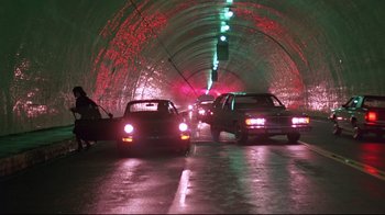 Movie still from “Flashdance” (1983), directed by Adrian Lyne – Cars driving down a street at night in a tunnel; Wide shot, Low angle