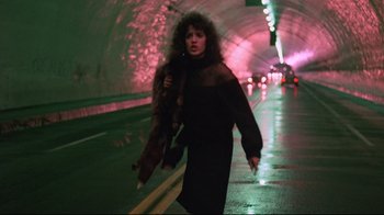Movie still from “Flashdance” (1983), directed by Adrian Lyne – A woman walking down a street in a tunnel; Wide shot, Low angle