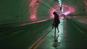 Movie still from “Flashdance” (1983), directed by Adrian Lyne – A woman walking down a street holding an umbrella; Wide shot, High angle