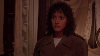Movie still from “Flashdance” (1983), directed by Adrian Lyne – A young woman with curly hair wearing a brown jacket; Close Up shot, Over the shoulder angle
