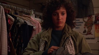 Movie still from “Flashdance” (1983), directed by Adrian Lyne – A woman in a room with clothes hanging on a rack; Close Up shot, Low angle