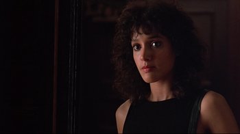 Movie still from “Flashdance” (1983), directed by Adrian Lyne – A young woman with curly black hair looking at the camera; Close Up shot, Low angle