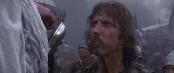 Movie still from “Flesh+Blood” (1985), directed by Paul Verhoeven – A person holding a metal object; Close Up shot, Low angle