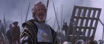 Movie still from “Flesh+Blood” (1985), directed by Paul Verhoeven – An old man with a beard and a helmet is yelling; Close Up shot, Low angle