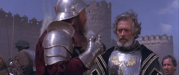 Movie still from “Flesh+Blood” (1985), directed by Paul Verhoeven – Two men dressed in medieval armor , one of which has a sword in his other hand; Medium shot, Over the shoulder angle