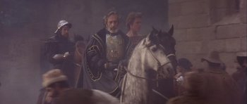 Movie still from “Flesh+Blood” (1985), directed by Paul Verhoeven – A man riding on the back of a white horse; Medium shot, High angle