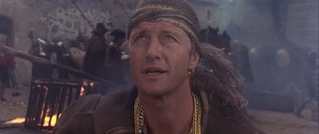 Movie still from “Flesh+Blood” (1985), directed by Paul Verhoeven – A person wearing a hat; Close Up shot, Over the shoulder angle