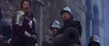 Movie still from “Flesh+Blood” (1985), directed by Paul Verhoeven – Two men in medieval garb are standing next to each other; Medium shot, Low angle