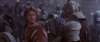 Movie still from “Flesh+Blood” (1985), directed by Paul Verhoeven – A group of men in medieval garb standing in front of each other; Close Up shot, Over the shoulder angle