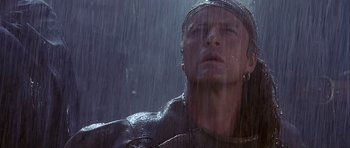 Movie still from “Flesh+Blood” (1985), directed by Paul Verhoeven – A man in a leather jacket looking up in the rain; Close Up shot, Low angle
