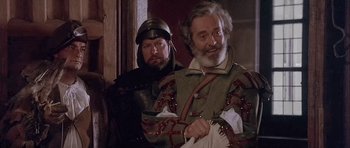 Movie still from “Flesh+Blood” (1985), directed by Paul Verhoeven – Two men dressed in medieval clothing , one of which is holding a knife; Medium shot, Over the shoulder angle