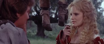 Movie still from “Flesh+Blood” (1985), directed by Paul Verhoeven – A woman holding a cigarette in her mouth; Medium shot, Over the shoulder angle