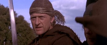 Movie still from “Flesh+Blood” (1985), directed by Paul Verhoeven – A person wearing a hat; Close Up shot, Low angle