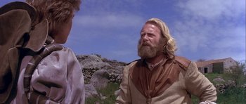Movie still from “Flesh+Blood” (1985), directed by Paul Verhoeven – A man with long blond hair and a beard talking to another man; Close Up shot, Low angle