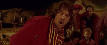 Movie still from “Flesh+Blood” (1985), directed by Paul Verhoeven – A man with long hair and a red jacket; Close Up shot, Low angle