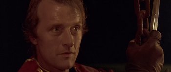 Movie still from “Flesh+Blood” (1985), directed by Paul Verhoeven – A man's face in the dark; Close Up shot, Low angle