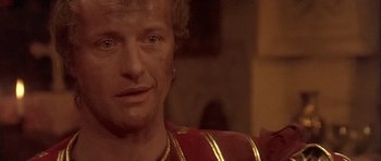 Movie still from “Flesh+Blood” (1985), directed by Paul Verhoeven – A person wearing a red and gold outfit; Close Up shot, Over the shoulder angle