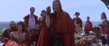 Movie still from “Flesh+Blood” (1985), directed by Paul Verhoeven – A group of people dressed in medieval clothing; Medium shot, Over the shoulder angle