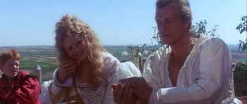 Movie still from “Flesh+Blood” (1985), directed by Paul Verhoeven – A man and a woman holding hands and smiling; Close Up shot, High angle