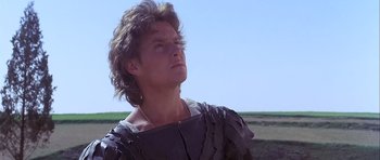 Movie still from “Flesh+Blood” (1985), directed by Paul Verhoeven – A man with long brown hair wearing a black shirt; Close Up shot, Low angle