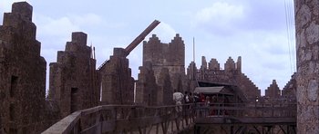 Movie still from “Flesh+Blood” (1985), directed by Paul Verhoeven – A group of people standing on top of a wooden bridge; Extreme Wide shot, Low angle