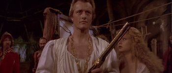 Movie still from “Flesh+Blood” (1985), directed by Paul Verhoeven – A person holding a sword in a room; Close Up shot, Low angle