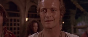 Movie still from “Flesh+Blood” (1985), directed by Paul Verhoeven – A person wearing a necklace; Close Up shot, Over the shoulder angle