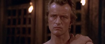 Movie still from “Flesh+Blood” (1985), directed by Paul Verhoeven – A man's face in a dark room; Close Up shot, Over the shoulder angle