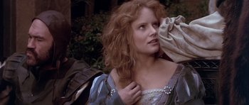 Movie still from “Flesh+Blood” (1985), directed by Paul Verhoeven – A woman with red curly hair and a blue dress; Close Up shot, Over the shoulder angle