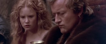 Movie still from “Flesh+Blood” (1985), directed by Paul Verhoeven – A man and a woman are sitting next to each other; Close Up shot, Over the shoulder angle