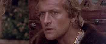 Movie still from “Flesh+Blood” (1985), directed by Paul Verhoeven – A person wearing a gold earring; Close Up shot, Over the shoulder angle