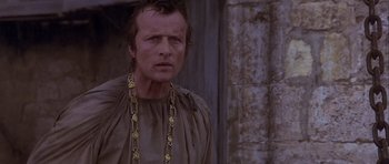 Movie still from “Flesh+Blood” (1985), directed by Paul Verhoeven – A person wearing a chain around their neck; Close Up shot, Low angle